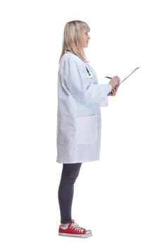 side view. young female doctor making notes in a clipboard . isolated on a white background.