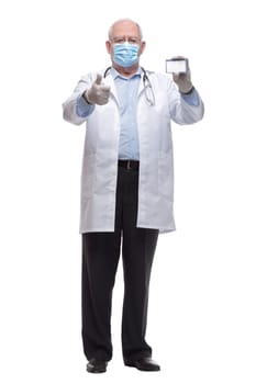 in full growth. doctor in protective mask showing his visiting card. isolated on a white background