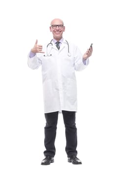 in full growth. smiling doctor with a smartphone. isolated on a white background.