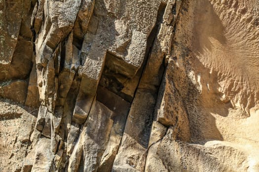 Detail on cracked stone layers, some of them covered with lichen