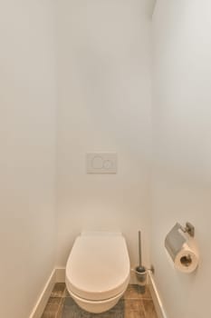 a toilet in the corner of a white room with tile flooring and wall mounted toilet paper on the walls