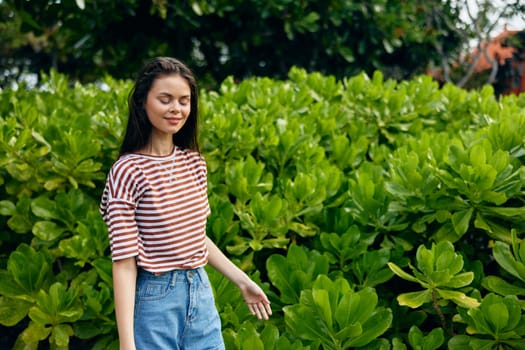 young woman fashion smiling striped beauty active walk beautiful lifestyle nature sunset sunny t-shirt freedom female summer park black bag exercise