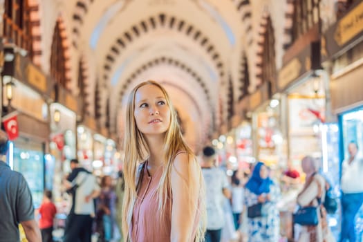 A tourist woman walks among the countless shops at the Grand Bazaar and Egyptian Bazaar in Istanbul. Shopping and travel in Turkey concept. Istanbul historical Egyptian Bazaar. Misir Carsisi, spice market. Turkiye.