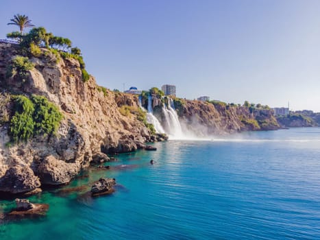 Lower Duden Falls drop off a rocky cliff falling from about 40 m into the Mediterranean Sea in amazing water clouds. Tourism and travel destination photo in Antalya, Turkey. Turkiye