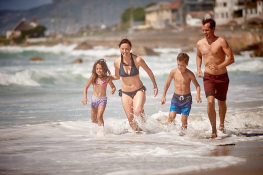 Summertime family fun. a family playing in the waves at the beach