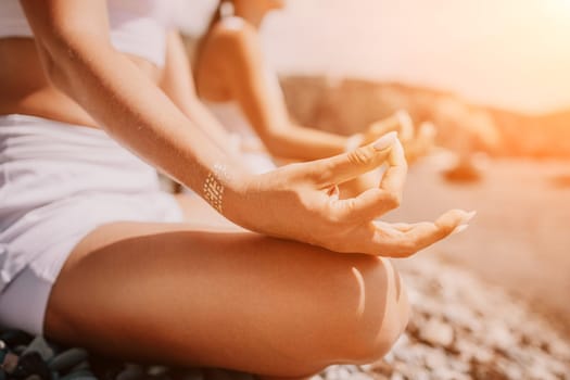 Woman sea yoga. Back view of free calm happy satisfied woman with long hair standing on top rock with yoga position against of sky by the sea. Healthy lifestyle outdoors in nature, fitness concept.