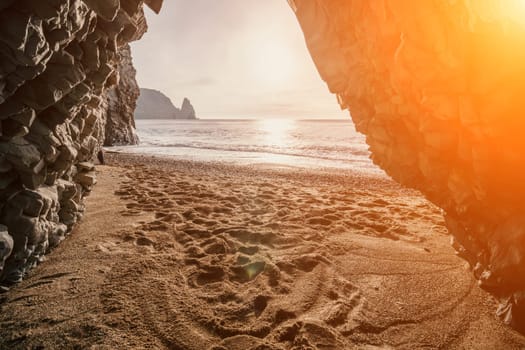 Dramatic Seascape over the beach during sunset, with rocky volcanic cliff is lit by the warm sunset. Clear sky no clouds. Nobody. The concept of calmness silence and unity with nature. Selective focus