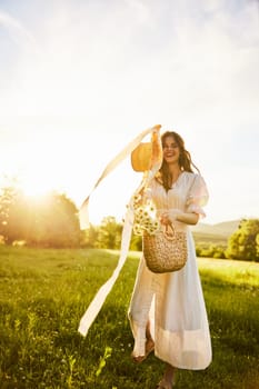a happy woman stands in a chamomile field in a light dress and tosses her hat towards the camera. High quality photo