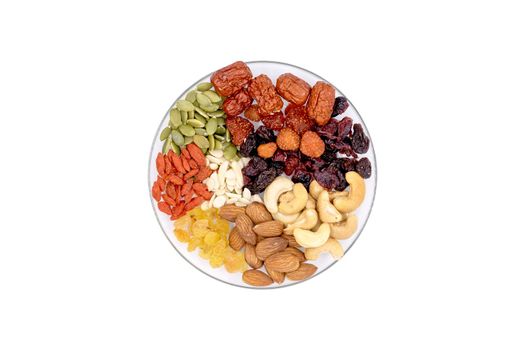 Top view group of whole grains and dried fruit in a glass plate isolated on white background.