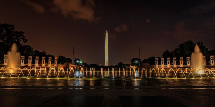 Washington DC, USA - July 01, 2015: Washington Monument stands behind the fountain of National World War II Memorial.