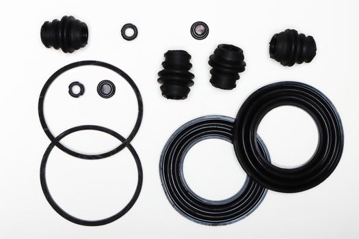 Rubber rings, gaskets, oil seals, machine repair parts. A set of spare parts for servicing the braking system of a vehicle. Details on white background, copy space available.