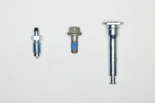 Metal finger, pin and bolt, machine repair parts. A set of spare parts for servicing the braking system of a vehicle. Details on white background, copy space available.