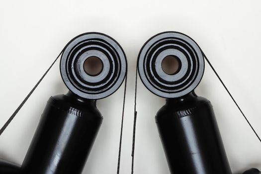Two silent blocks on shock absorbers, parts for car repair. A set of spare parts for servicing the chassis of the vehicle. Details on white background, copy space available.