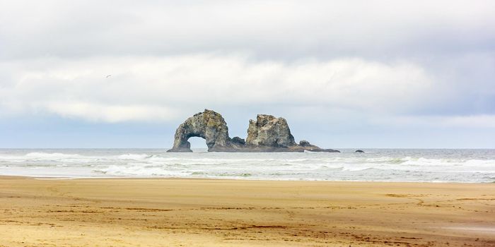 Two 100-foot-high rocks offshore in the Pacific Ocean, at Rockaway beach, Oregon.