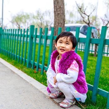 Adorable girl enjoys play time on the street, smiling.