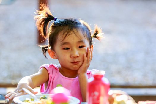 Adorable girl making faces in the park