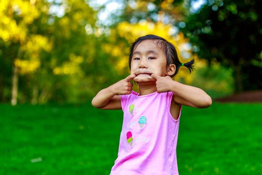 Adorable girl making faces in the park