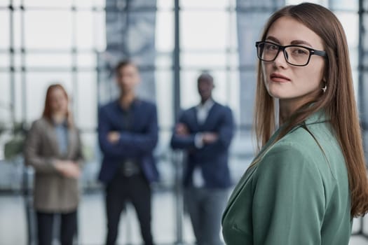 Portrait of a successful confident businesswoman. Pretty young business woman in an elegant green jacket standing in the office and looking at the camera