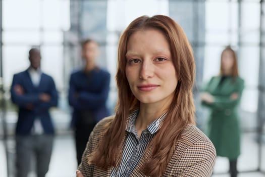 Portrait of a confident young businesswoman standing with her arms crossed in an office