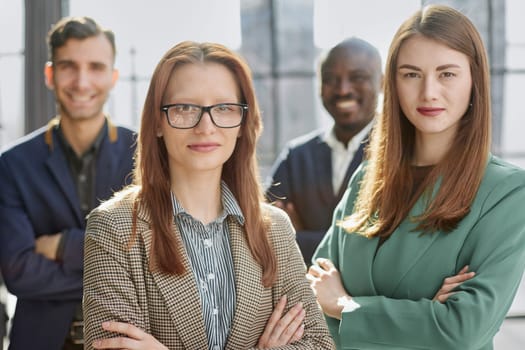 Portrait of four office workersr arms over their chest.