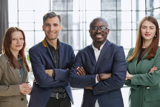 a team of businessmen stand in a trendy office with their arms crossed.