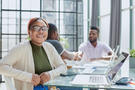 Portrait Of Businesswoman In Modern Open Plan Office With Business Team Working In Backgroun