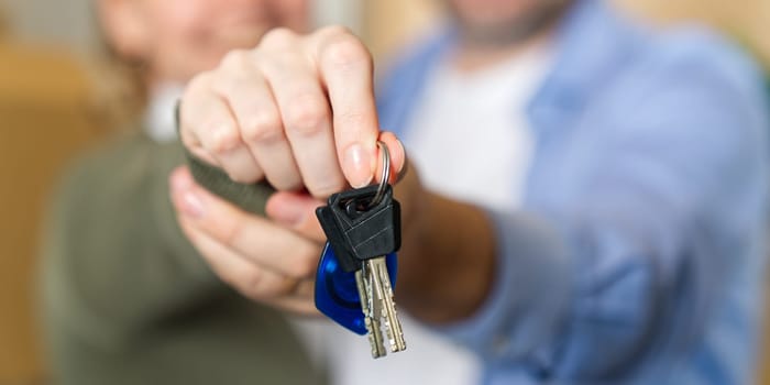 Couple showing keys to new apartment. real estate mortgage, loan concept. moving in new house. Young smiling couple holding their new house keys. first own apartment or house.