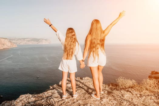 Close up portrait of mom and her teenage daughter hugging and smiling together over sunset sea view. Beautiful woman relaxing with her child.