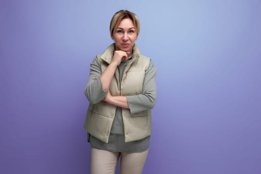 embarrassed blonde millennial woman in spring casual look on studio background with copy space.