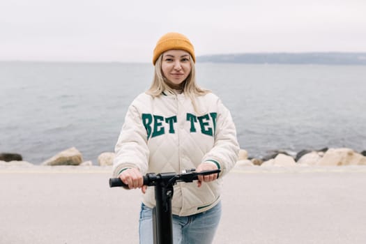 Milan, Italy - February 21, 2018: Attractive girl riding an electric scooter along the promenade in Europe.