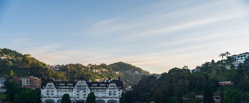 Long exposure shot of Quitandinha Palace's facade under a mesmerizing abstract sky made of clouds at dawn, signaling the beginning of a new day.