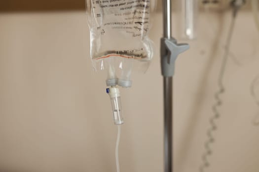 A ward in a hospital, a close-up of drops of saline in a drip, the solution is slowly falling. Treatment of the disease, medicine after surgery.