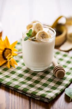 Sweet homemade yogurt with bananas and honey in a glass