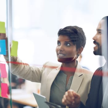 Cropped shot of two colleagues working at the idea board.