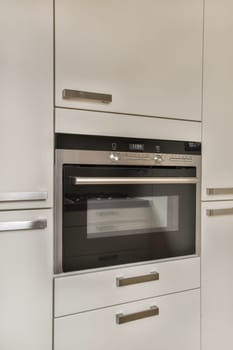 a white kitchen with an oven in it's center and two drawers on the other side of the wall