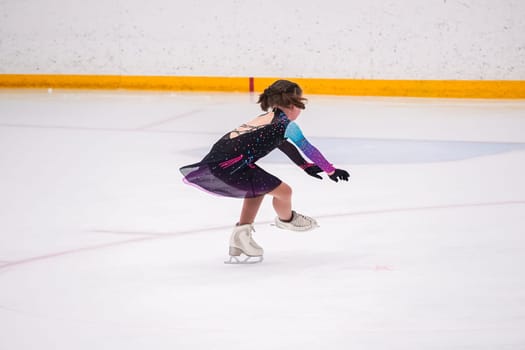 Little girl practicing before her figure skating competition at the indoor ice rink.