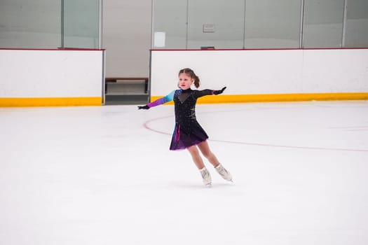 Little girl practicing before her figure skating competition at the indoor ice rink.