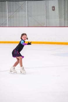 Little girl practicing before her figure skating competition at the indoor ice rink.