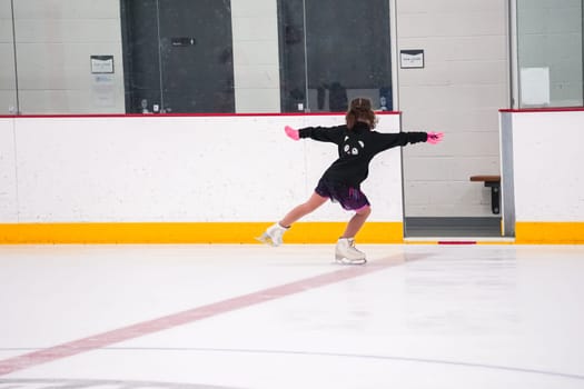 Little girl practicing before her figure skating competition at the indoor ice rink.