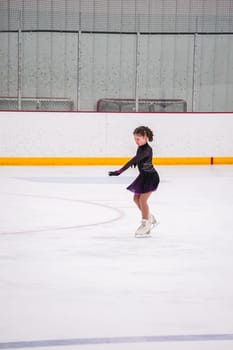 Little girl practicing before her figure skating competition at the indoor ice rink.