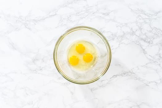 Flat lay. Mixing wet ingredients in a large glass mixing bowl to bake American flag mini cupcakes.