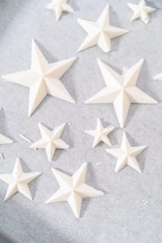 Filling silicone mold with white melted chocolate to make chocolate chocolate stars for American flag mini cupcakes.