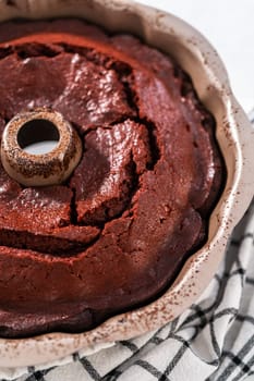 Cooling freshly baked red velvet bundt cake on a kitchen counter.