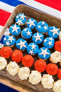 Arranging mini vanilla cupcakes in the shape of the American flag.