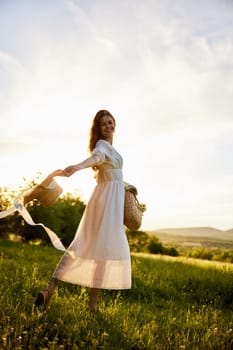 a woman in a light dress walks in nature holding a hat in her hands lit from the back by the sun. High quality photo