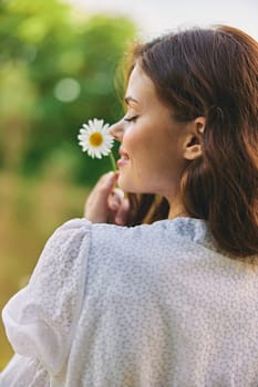 close-up portrait of a woman with a chamomile flower on the background of the lake. High quality photo