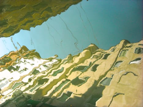 The houses of Venice reflected on the water of a canal form an abstract image