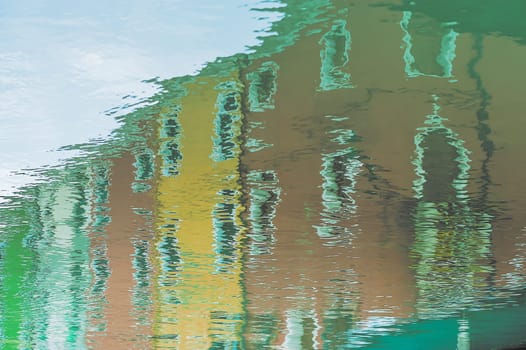 The characteristic colored houses of Burano (Venice) reflected on the water of a canal