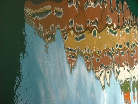 The characteristic colored houses of Burano (Venice) reflected on the water of a canal