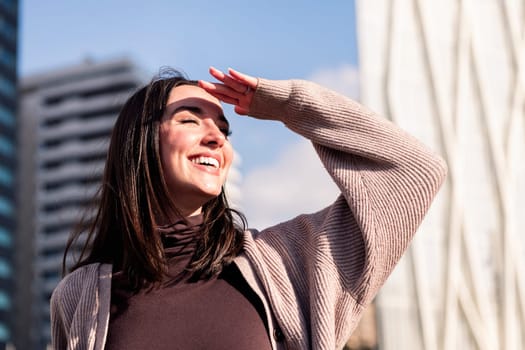 smiling young woman enjoying the city on sunny day, concept of happiness and urban lifestyle